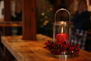 candle in holder with cranberries around it